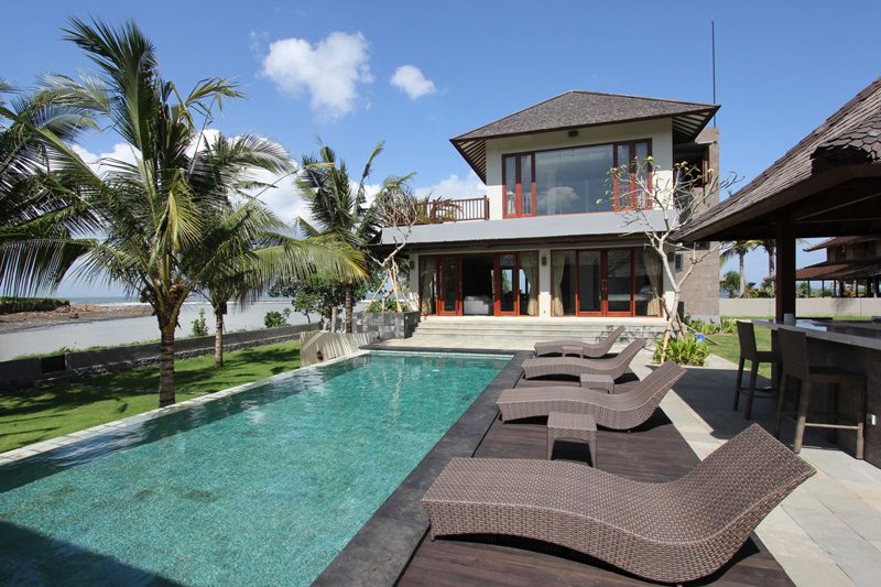 Sunloungers around the pool looking across to the villa